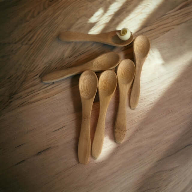 een aantal bamboe houten lepeltjes op een houten tafel 